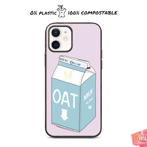 Puede incluir: Una funda de teléfono rosa con una ilustración de dibujos animados de una caja de leche de avena. La caja es azul y blanca con el texto "OAT MILK NO COW" y una fecha de caducidad "OCT 21". La funda del teléfono está hecha de material 100% compostable.