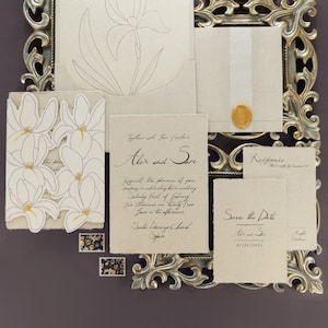 May include: A wedding invitation suite with a floral design. The invitation is printed on textured paper and features the names "Alex and Sun" and the date "February 1st, 2025". The save the date card is also printed on textured paper and features the text "Save the Date" and the date "02/01/2025".