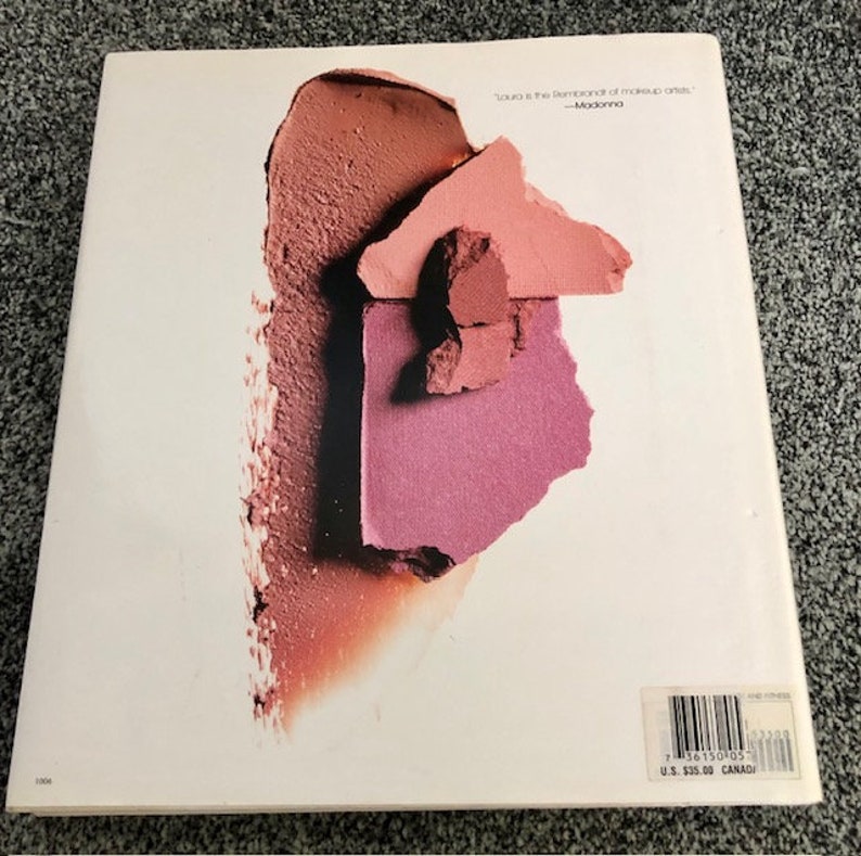May include: A close-up of a book cover with a pink, red, and brown makeup swatch. The text on the cover reads "'Stila is the Rembrandt of makeup artists.' -Madonna"