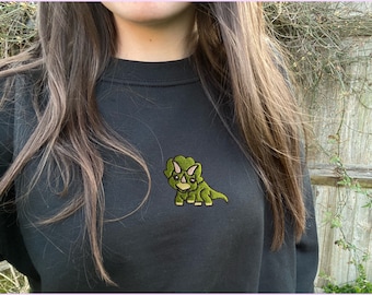 May include: Black sweatshirt with a green embroidered triceratops design.