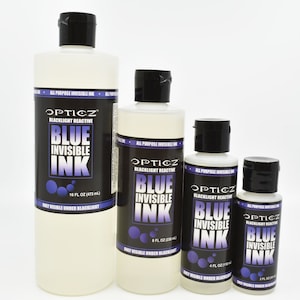 May include: Four clear plastic bottles of Opticz blacklight reactive blue invisible ink with black caps. The labels display the text Opticz, Blacklight Reactive, Blue Invisible Ink, and Only Visible Under Blacklight, with volumes of 16 fl oz, 8 fl oz, 4 fl oz, and 2 fl oz.