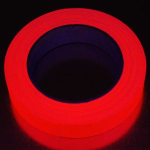 K&ouml;nnte beinhalten: Eine Rolle leuchtend rotes Leuchtband. Das Band ist um einen schwarzen Kern gewickelt.