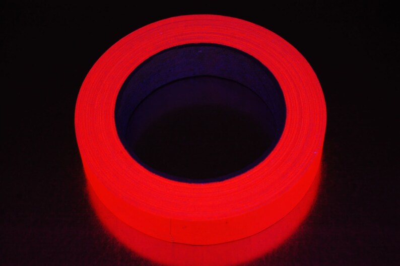 K&ouml;nnte beinhalten: Eine Rolle leuchtend rotes Leuchtband. Das Band ist um einen schwarzen Kern gewickelt.