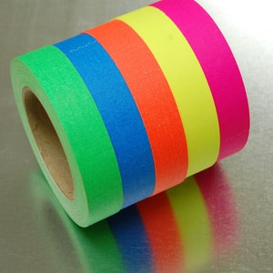 K&ouml;nnte beinhalten: Eine Rolle farbiges Malerband mit gr&uuml;nen, blauen, orangen, gelben und pinkfarbenen Streifen.