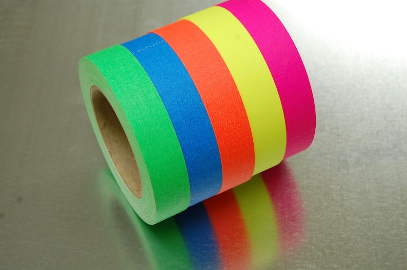 K&ouml;nnte beinhalten: Eine Rolle farbiges Malerband mit gr&uuml;nen, blauen, orangen, gelben und pinkfarbenen Streifen.