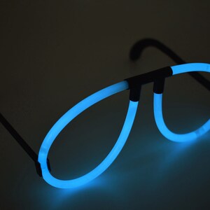 May include: A pair of blue glow-in-the-dark glasses with black plastic frames. The glasses are shaped like aviator sunglasses.
