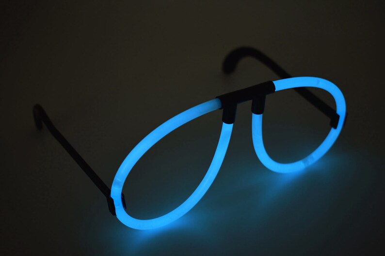 May include: A pair of blue glow-in-the-dark glasses with black plastic frames. The glasses are shaped like aviator sunglasses.
