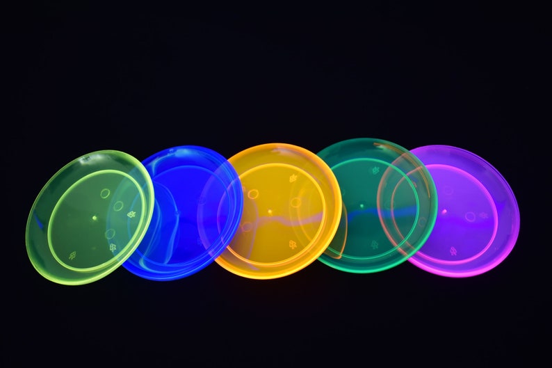 May include: Five neon-colored plastic plates in a row. The plates are green, blue, yellow, green, and purple.