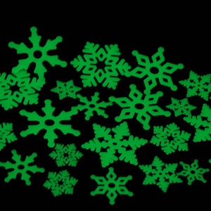 May include: A collection of green glow-in-the-dark snowflake stickers. The snowflakes are various sizes and shapes.