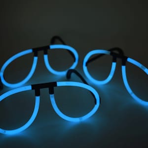 May include: Three pairs of blue glow-in-the-dark glasses. The glasses are shaped like aviator sunglasses.