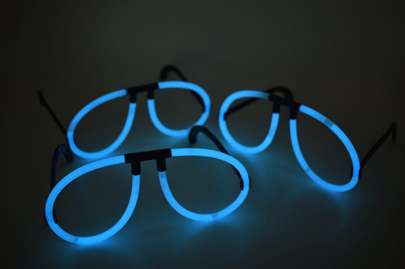 May include: Three pairs of blue glow-in-the-dark glasses. The glasses are shaped like aviator sunglasses.