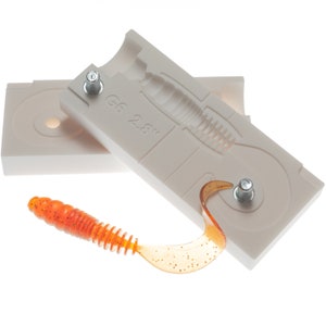 May include: A white plastic mold for making fishing lures, with a 2.8" lure partially removed from the mold. The lure is orange and has a speckled finish.