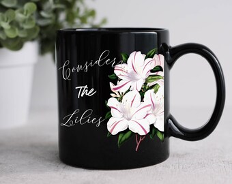May include: Black ceramic mug with a white floral design and the text "Consider the Lilies" in white cursive lettering.