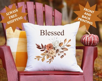 May include: White throw pillow with the word "Blessed" printed in brown text. The pillow features a watercolor floral design with fall colors, including orange, brown, and white.