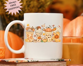 May include: White ceramic mug with a fall-themed design featuring five pumpkin spice lattes with whipped cream and fall leaves.