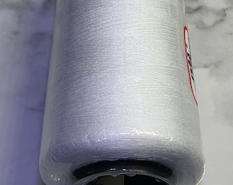 Puede incluir: Una bobina de hilo blanco envuelta en plástico transparente. La bobina está etiquetada como "WHITE" y tiene una etiqueta en blanco y negro con un logotipo.