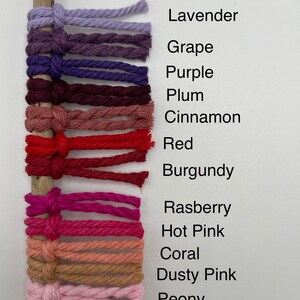 Puede incluir: Una colecci&oacute;n de 14 cordones de hilo de diferentes colores, atados a un palo de madera. Los colores son lavanda, uva, morado, ciruela, canela, rojo, burdeos, frambuesa, rosa fuerte, coral, rosa polvoriento, peon&iacute;a y malva.