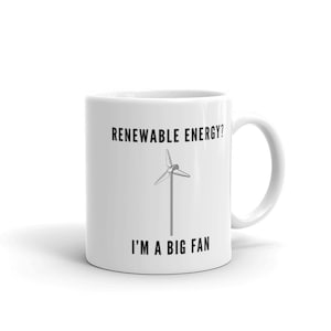 Op de afbeelding: Witte keramische mok met een zwarte afbeelding van een windturbine en de tekst "Herbruikbare energie? Ik ben een grote fan".