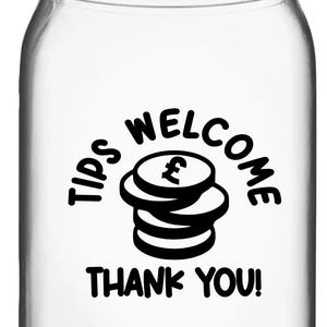 Op de afbeelding: Een glazen pot met een zilveren deksel. De pot heeft een zwarte sticker met de tekst "Tips Welcome" met een stapel munten en een pondteken. De sticker zegt ook "Thank You!"