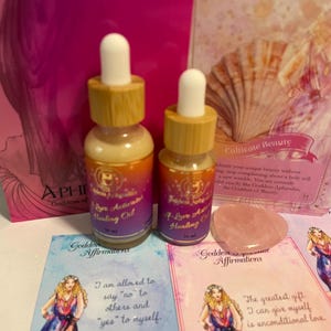 Puede incluir: Dos pequeños frascos de vidrio ámbar con tapas doradas y etiquetas que dicen "Self-Love Activator Healing Oil" y "F-Love Activator Healing Oil". Los frascos están sobre una superficie rosa y blanca con dos tarjetas que dicen "Goddess Affirmations". Las tarjetas presentan ilustraciones de mujeres y texto. Una tarjeta dice "Estoy permitida a decir "no" a otros y "sí" a mí misma." La otra tarjeta dice "El mayor regalo que puedo darme es el amor incondicional."