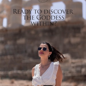 May include: A woman wearing sunglasses and a white dress with a black belt stands in front of an ancient stone structure. The text "READY TO DISCOVER THE GODDESS WITHIN?" is superimposed on the image.