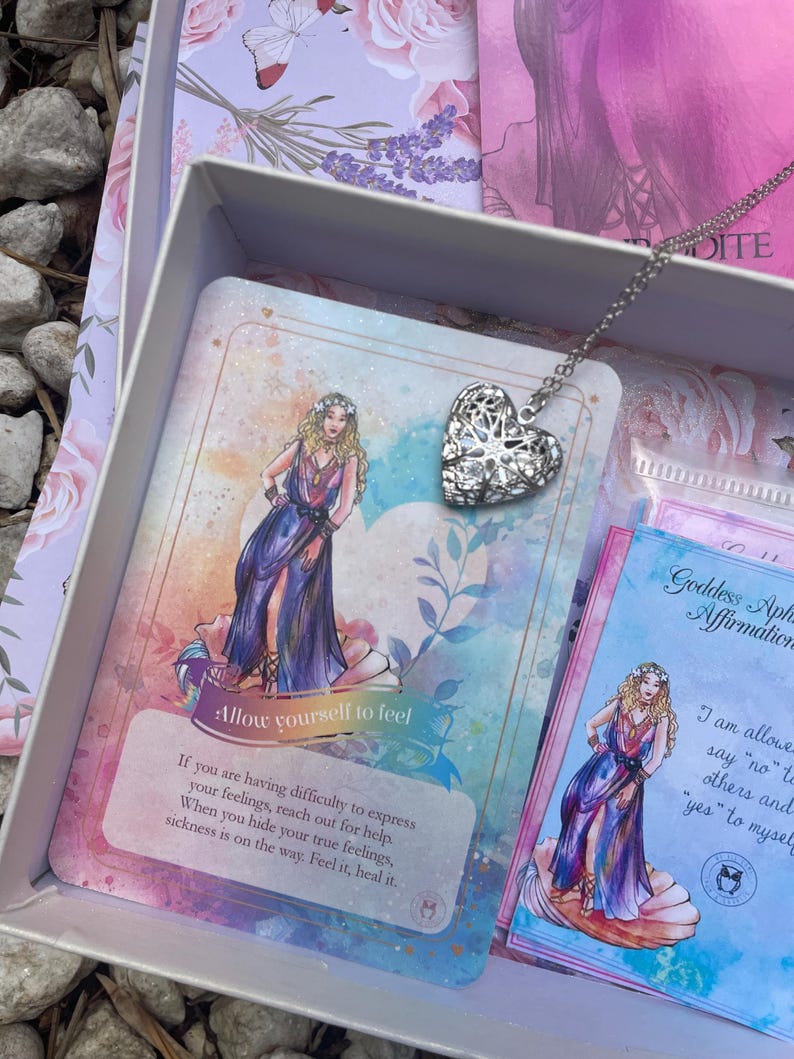 May include: A set of affirmation cards featuring a watercolor illustration of a woman in a blue dress and a silver heart locket necklace. The cards have text that reads "Allow yourself to feel" and "I am allowed to say "no" to others and "yes" to myself".