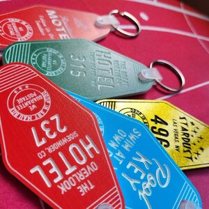 Puede incluir: Una colecci&oacute;n de seis llaveros de motel de estilo vintage. Los llaveros son rojos, verdes, azules, amarillos y blancos. Cada llavero presenta un nombre de motel y un n&uacute;mero de habitaci&oacute;n diferentes. Los llaveros est&aacute;n hechos de metal y pl&aacute;stico.