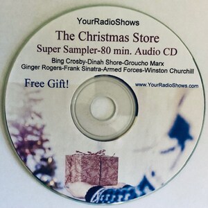 May include: A silver audio CD with the text "The Christmas Store" and "Super Sampler - 80 min. Audio CD." The disc features a festive design with a gift box and the words "Free Gift!" and "YourRadioShows.com."