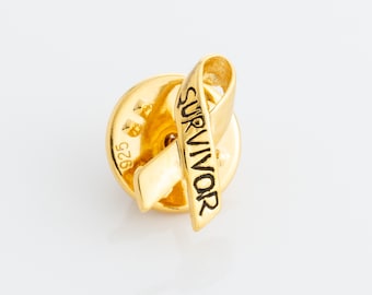 May include: Gold-toned pin with a yellow ribbon and the word "SURVIVOR" engraved on it. The back of the pin has the number "925" engraved on it.