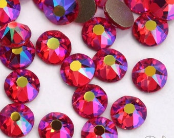 May include: Assortment of red iridescent rhinestones, with a variety of sizes and shapes. The rhinestones have a shiny, reflective surface.