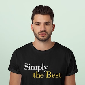Puede incluir: Una camiseta negra con texto blanco que dice "Simply the Best" en una fuente dorada.