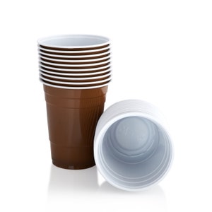 May include: A collection of brown plastic cups with white rims, alongside a stack of white plastic cups. These single-use cups are made from a lightweight material. Ideal for parties and gatherings, these cups are a practical choice.