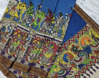 May include: A blue and cream colored silk saree with a traditional Indian design. The saree features a border with a gold trim and a colorful pattern of peacocks and other animals. The saree is a beautiful example of traditional Indian craftsmanship.
