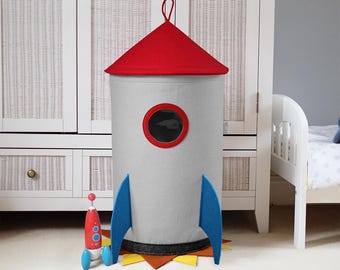 Cesta para guardar la ropa sucia con forma de cohete espacial