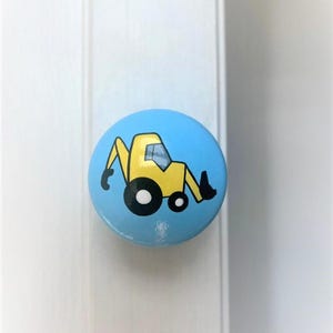 May include: A blue ceramic knob featuring a yellow cartoon excavator. This knob would be ideal for a child's bedroom or playroom.