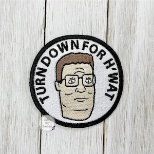 May include: Round embroidered patch featuring a cartoon portrait of a man with glasses. The patch has the text "TURN DOWN FOR H'WAT" in a black font around the edge. The man's face is in the center.