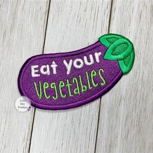 May include: Purple eggplant-shaped embroidered patch with green leaves and the text "Eat Your Vegetables" in white.
