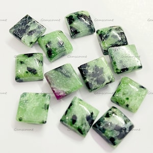 May include: A collection of square-cut gemstones with a mix of green and black inclusions. The stones have a polished, glossy finish. The word "Gemscount" is printed on the surface of the image.