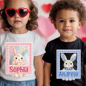 May include: Two children wearing t-shirts with bunny graphics. One child wears a white shirt with a pink plaid frame around a bunny image and the name "Sophia". The other child wears a black shirt with a blue plaid frame around a bunny image and the name "Andrew".