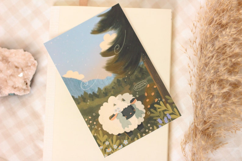 Pu&ograve; includere: Una pecora bianca e soffice con la faccia nera e una corona di fiori blu si trova in un campo di fiori. La pecora guarda in alto verso un albero verde con un cielo blu e nuvole bianche sullo sfondo. Il testo "Sometimes you just need to wander" &egrave; in una nuvola di pensiero sopra la pecora.