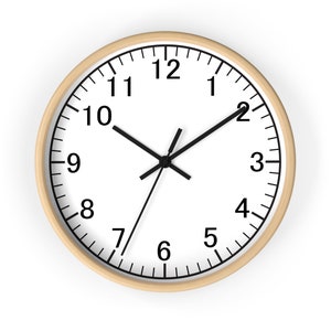 May include: A round wall clock with a light wood frame. The clock face is white with black numerals and hands. The clock hands indicate the time is approximately 10:10.