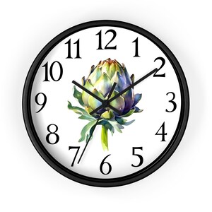 May include: A black framed clock with white face and black numbers. The clock features a watercolor painting of an artichoke in the center.