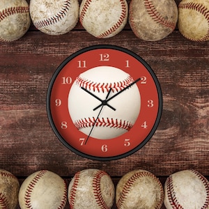 May include: A red and white baseball clock with black hands and numbers. The clock is surrounded by baseballs.