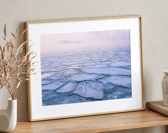 May include: A framed photograph of a frozen lake with cracked ice and a foggy background. The photo is displayed on a wooden shelf with a vase and other decor.
