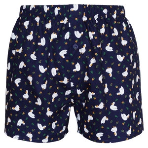May include: Navy blue boxer shorts with a white duck pattern. The ducks are facing different directions and are scattered across the fabric.
