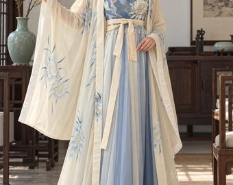 May include: A floor-length dress featuring a blue bodice with white floral embroidery and a layered blue skirt. It is paired with a sheer, cream-colored open-front robe adorned with blue and white floral patterns and a matching cream waist tie.