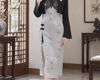 May include: A light gray sleeveless dress featuring a black butterfly appliqué on the chest, a side slit, and black knot buttons, paired with a black long-sleeved bolero jacket with floral embroidery on the lapel and light-colored pointed heels.