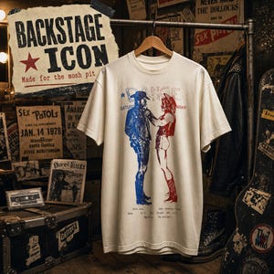 May include: A cream-colored short-sleeve t-shirt featuring a graphic print of two figures facing each other. The figure on the left is printed in blue, and the figure on the right is printed in red. The text "DANCE" appears above the figures.