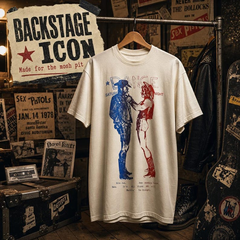 May include: A cream-colored short-sleeve t-shirt featuring a graphic print of two figures facing each other. The figure on the left is printed in blue, and the figure on the right is printed in red. The text "DANCE" appears above the figures.