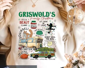 May include: Cream-colored sweatshirt with a graphic design featuring text and illustrations from the movie "National Lampoon's Christmas Vacation." The design includes a squirrel, RV, station wagon, and various quotes.